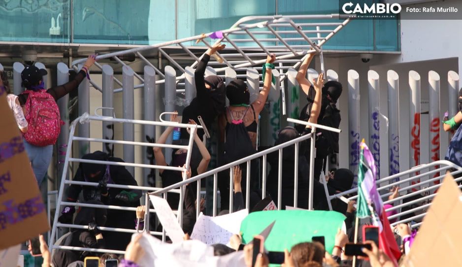 #8M: En VIVO; feministas tiran valla en la Fiscalía e inician a pintar paredes